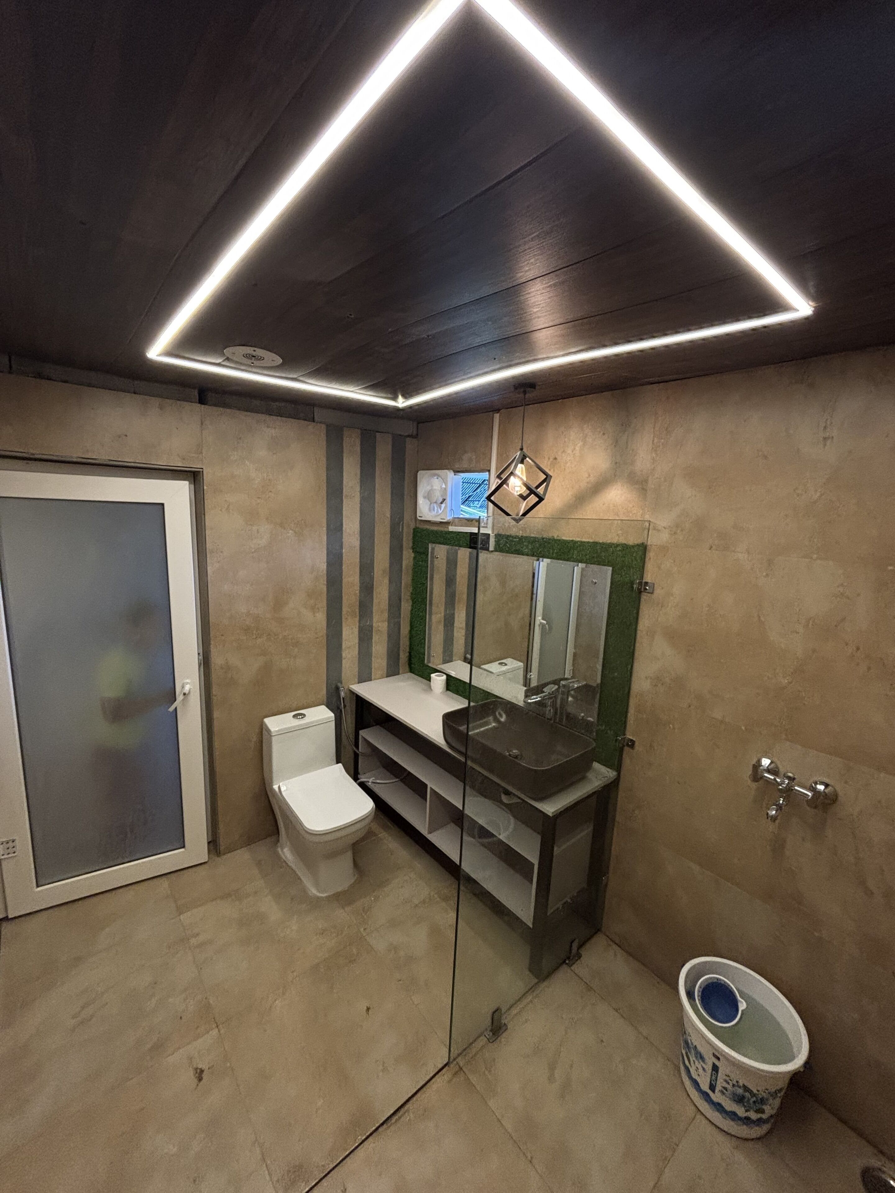 A modern bathroom with a toilet, sink, and mirror.
