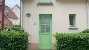A building with a green door, a small window, and a number '35' on the wall. - Charming Cottage - Near Beach and Shops (Fort-Mahon-Plage)