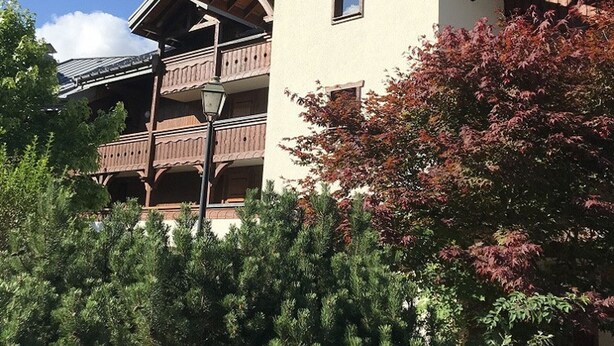 A multi-story building with wooden balconies and a traditional architectural style.