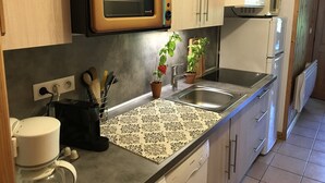 A kitchen with a microwave, sink, and a coffee machine.