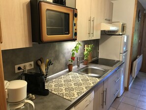 A kitchen with a microwave, sink, and a coffee machine. - Charming apartment with WiFi in Samoëns (Samoëns)