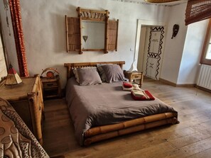 A bedroom with a wooden bed, a nightstand, a dresser, and a mirror on the wall. - Spacious apartment in Samoëns, 3 bedrooms, WiFi, 10 people (Samoëns)
