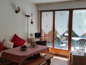 Una habitación acogedora con una mesa de comedor, una computadora portátil y vistas al exterior.