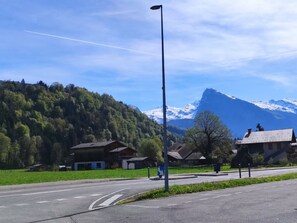 Una carretera con una glorieta, casas y una montaña al fondo.