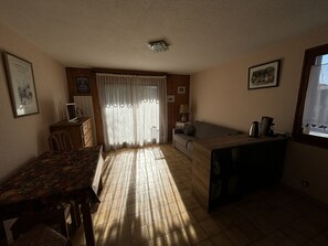 A compact living space with a dining area, kitchenette, and a sofa. - Apartment in Samoëns with Wifi, ideal for 3 pers. (Samoëns)