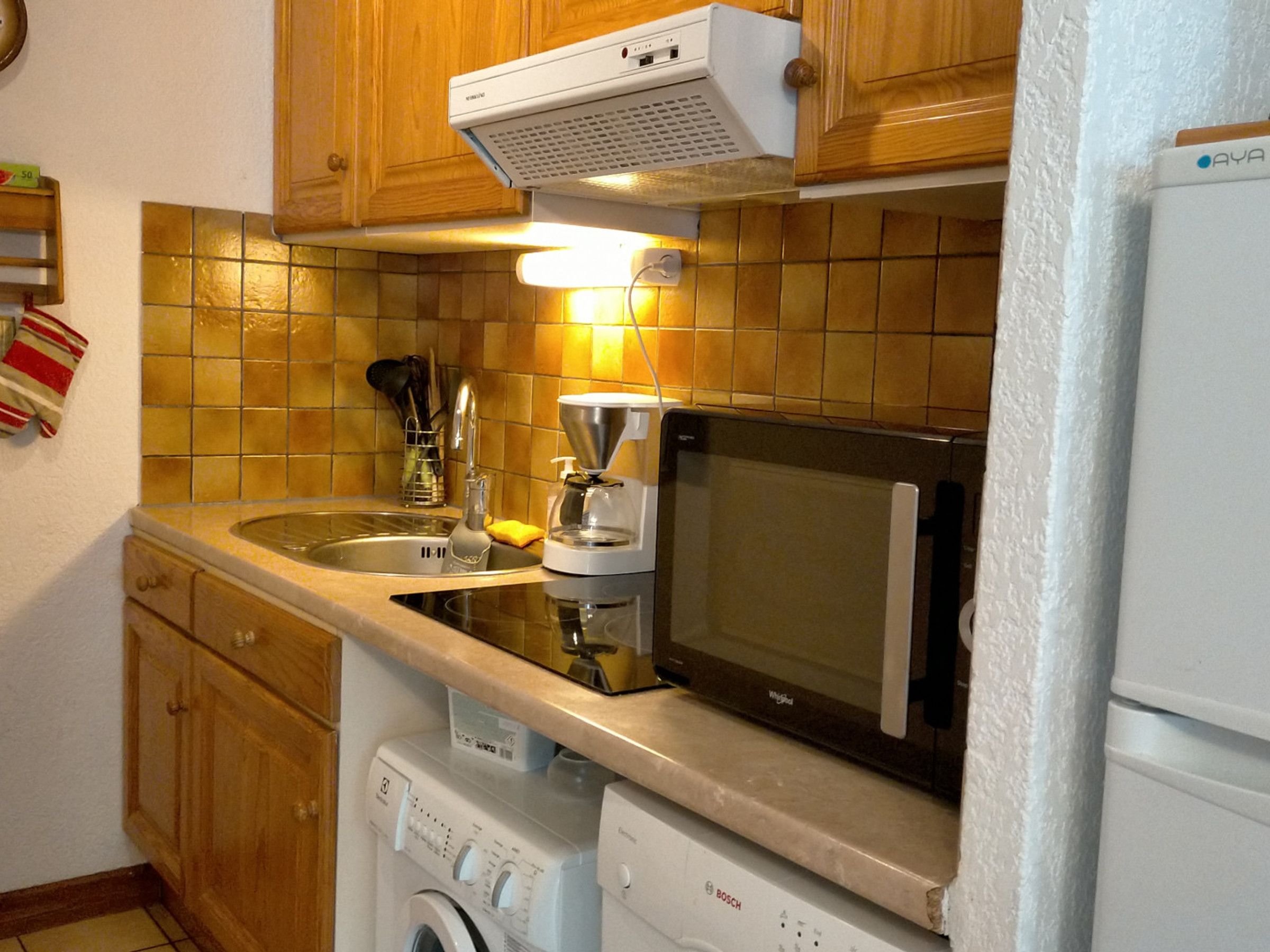 A kitchen with wooden cabinets, a microwave, a coffee maker, and a dishwasher.