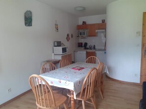 A compact kitchen with a microwave, coffee maker, and a small refrigerator.