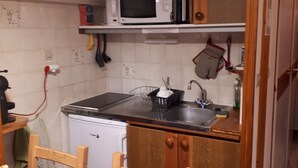Una cocina compacta equipada con microondas, lavavajillas y un lavabo.