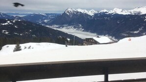 A mountainous landscape with snow-covered peaks and a building in the valley. - Cozy studio for 5 people in Samoëns (Samoëns)