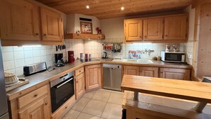 A kitchen with wooden cabinets, a dishwasher, a microwave, and a toaster.
