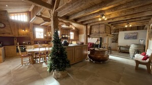 A rustic wooden interior with a kitchen, dining area, and a Christmas tree. - Spacious chalet in Samoëns, 6 bedrooms, perfect for 14 people with Wifi (Samoëns)