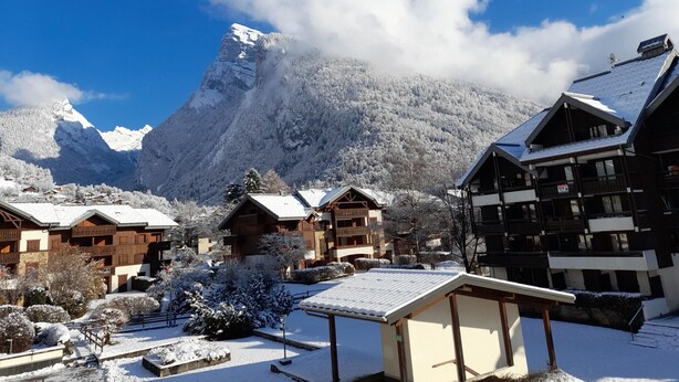 A snow-covered mountain village with chalet-style buildings, a clear blue sky, and a prominent snow-capped peak in the background. - Cozy studio, sleeps 4, Samoëns (Samoëns)