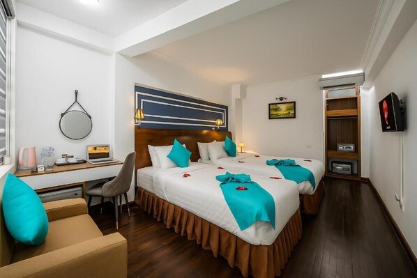 Een hotelkamer met een bed, bureau, stoel en een televisie.