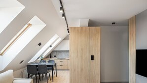 Un appartement moderne de style « loft », comprenant un coin repas, une kitchenette et un grand placard.