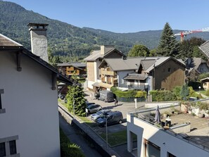 Un quartier résidentiel avec des maisons, une route et une chaîne de montagnes en arrière-plan.