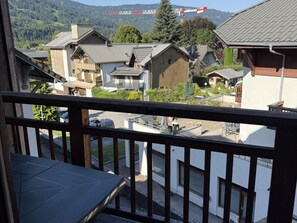 A residential area with multiple houses, a visible balcony, and a distant construction crane.