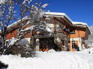 A wooden chalet with a balcony, surrounded by snow-covered trees and a clear blue sky. - Charming Villa in Samoëns with Wifi and 2 Bedrooms (Samoëns)