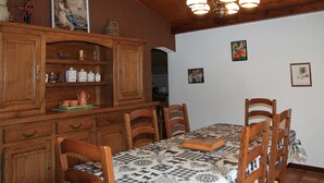 Un comedor con armarios de madera, mantel estampado y una araña.
