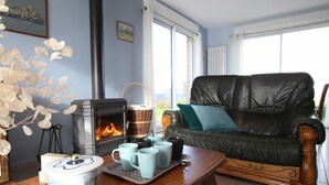 Ein gemütliches Wohnzimmer mit Kamin, einer Ledersofa und einem Tisch mit Tassen.