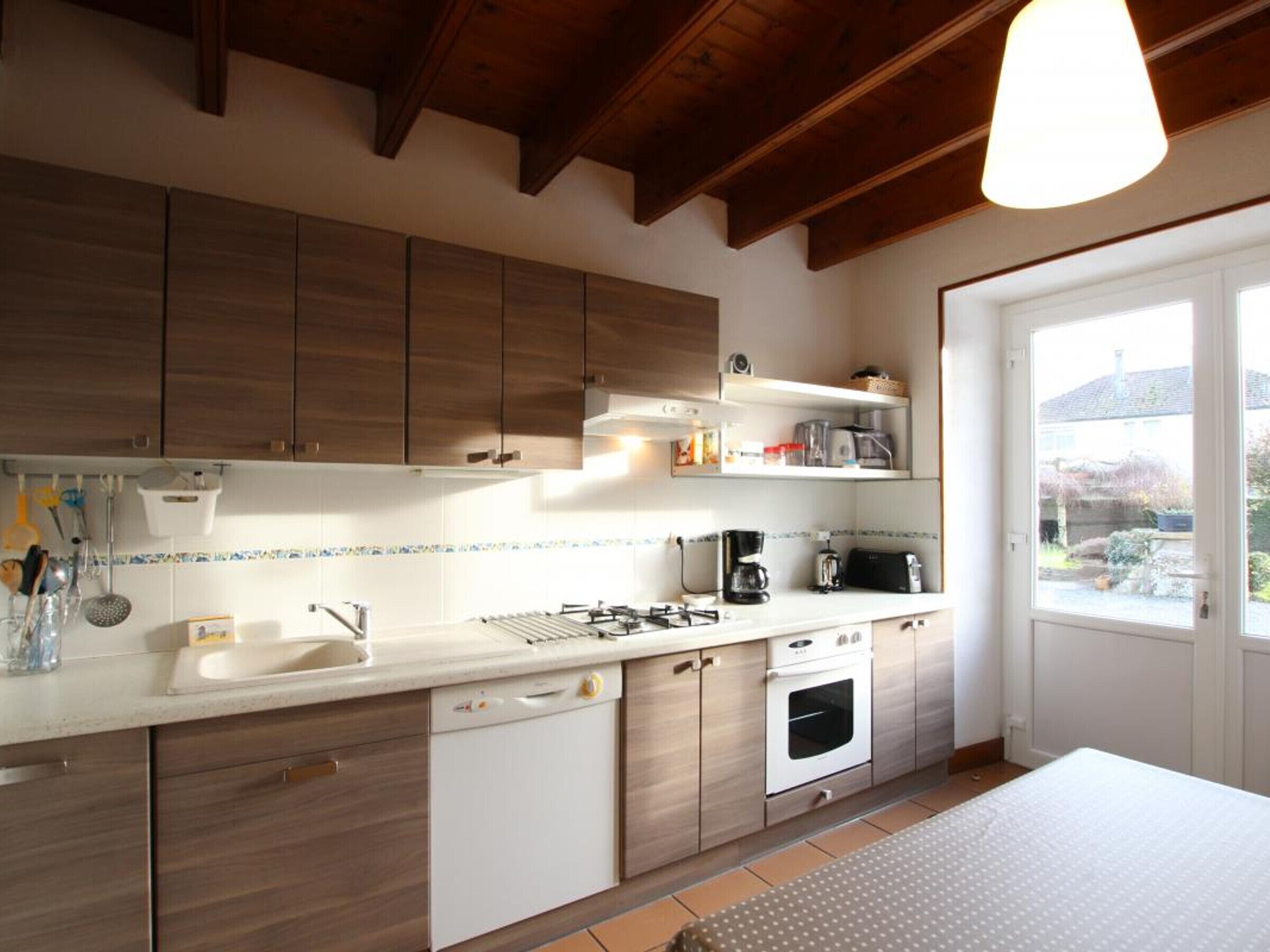 Une cuisine moderne avec des meubles en bois, un plan de travail blanc et un four encastré.