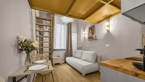 A compact living space with a dining area, sofa, and kitchenette. - Warsaw Praga Studio – Central Access & Parking (Warszawa)