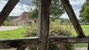 Una valla de madera rústica con un edificio de piedra al fondo.