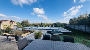 Une terrasse sur le toit, dotée d’une verrière, d’un espace salon extérieur et offrant une vue sur le paysage environnant.