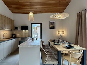 A modern kitchen with a central island, wooden ceiling, and pendant lighting. - New 4-room apartment for 6 people with terrace in Briançon (Briançon)