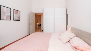 Une chambre à coucher comprenant un lit, une armoire et une porte donnant sur une salle de bain.