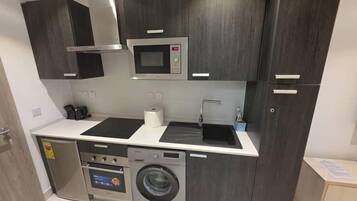 Full-size fridge, microwave, stovetop, cookware/dishes/utensils