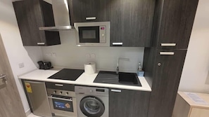 Full-size fridge, microwave, stovetop, cookware/dishes/utensils