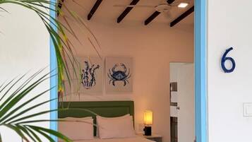 A bedroom with a bed, a nightstand, a green bench, and a wall number 6.