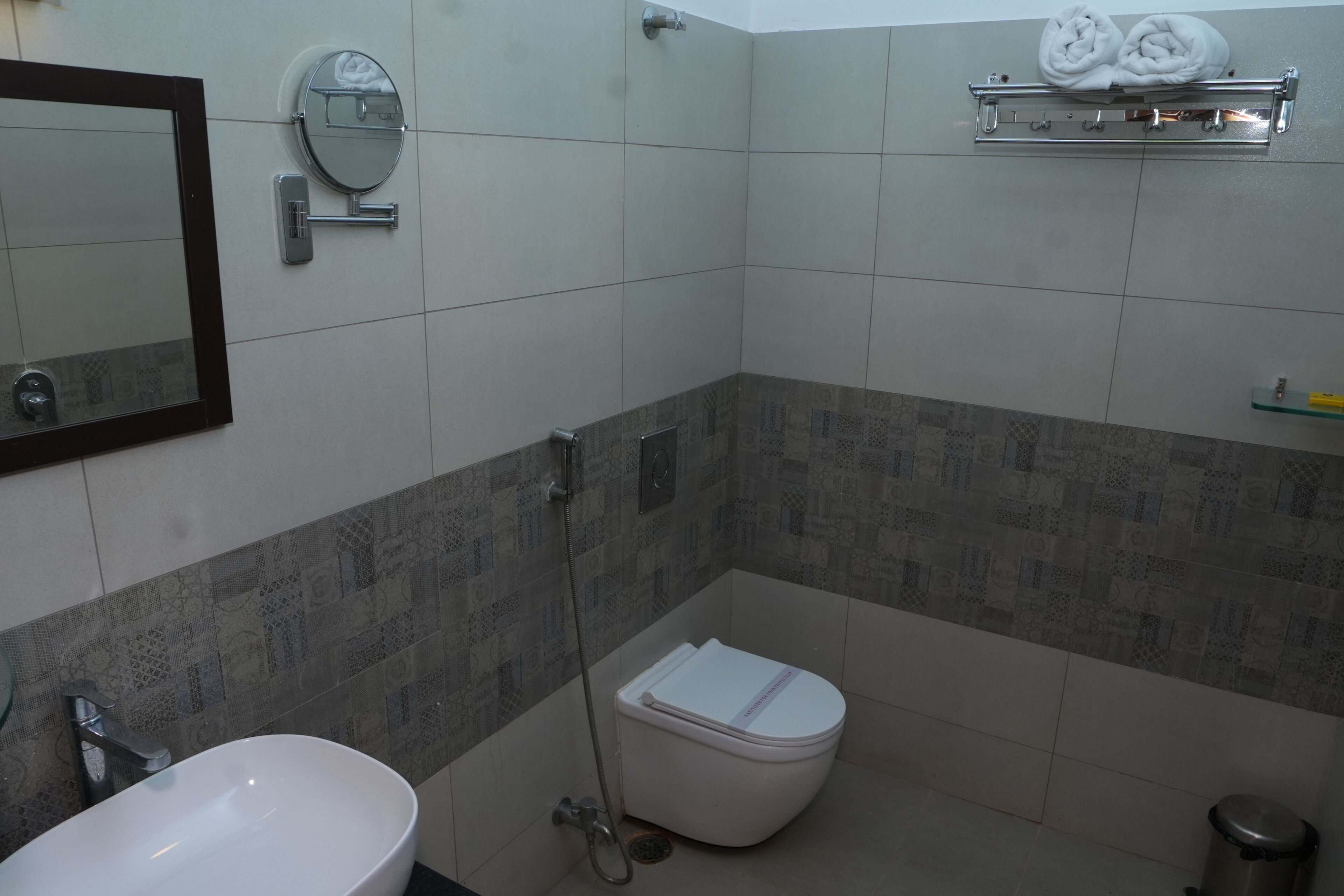 A bathroom with a sink, toilet, shower, and a towel rack.