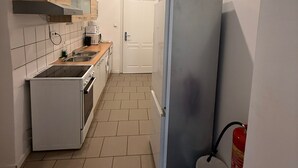 A compact kitchen with a stove, sink, and a refrigerator. - Smart 2BR Apt 10 Min from Westbahnhof (Vienna)