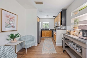 A compact kitchen with wooden cabinets, a built-in microwave, and a coffee maker on the counter.