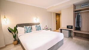 A bedroom with a bed, bedside tables, a desk, a small refrigerator, and a wardrobe. - Kingston Hotel 6 Changkat Bukit Bintang (Kuala Lumpur)