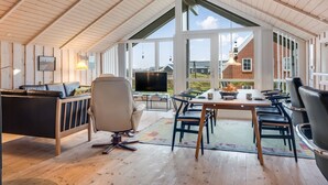 A spacious loft with a high ceiling, large windows, a dining area, and a cozy seating area. - "Bryngeir" - 100m from the sea by Interhome (Harboøre)