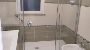A bathroom with a glass-enclosed shower, a sink, and a bidet. - Tramonti d' alba bed and breakfast (Terrasini)