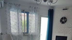 A bedroom with a bed, a nightstand, a lamp, a fireplace, and a window with curtains. - Tramonti d' alba bed and breakfast (Terrasini)