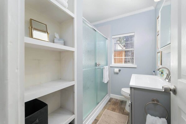 A bathroom with a glass shower enclosure, a sink, and a toilet. - Blue Palm Retreat - Team Joseph Ellen (Jacksonville)