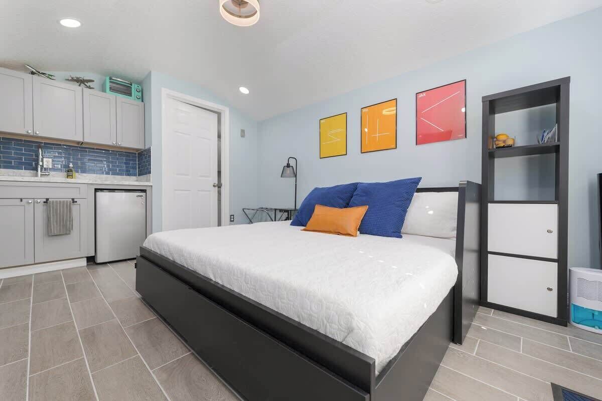 Une chambre avec un lit, une petite kitchenette et une salle de bain.