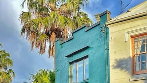 A two-story building with a teal facade and a red door. - Balmain Village Retreat | Sleeps 3 | Parking | City 3kms (Balmain)