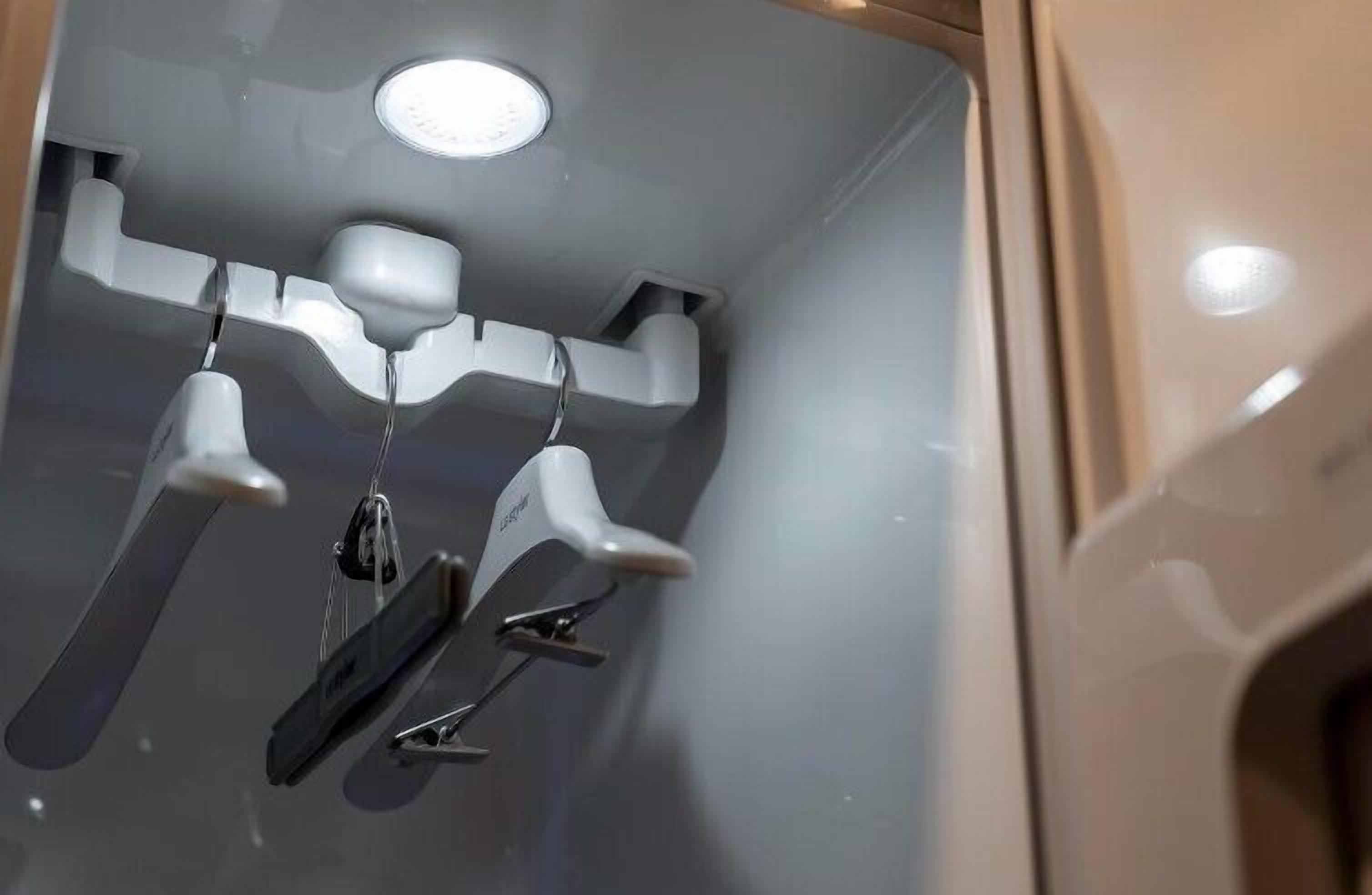 A modern bathroom with a sleek design, featuring a built-in shower with a curved ceiling and a visible light fixture.