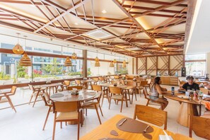 Un restaurant moderne avec des meubles en bois et des luminaires suspendus.