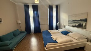 Een slaapkamer met een bed, een bank, een schilderij en een plafondlamp.