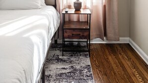 A bedroom with a bed, a nightstand with a lamp, and sheer curtains. - Pet-Friendly Broad Ripple Home W/ Fenced Backyard (Indianapolis)