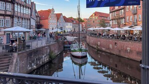 A canal with boats, historic buildings, and outdoor seating areas.