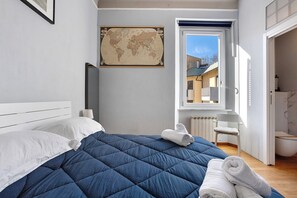 Un dormitorio con cama, un mapa mundial, una ventana y un baño.