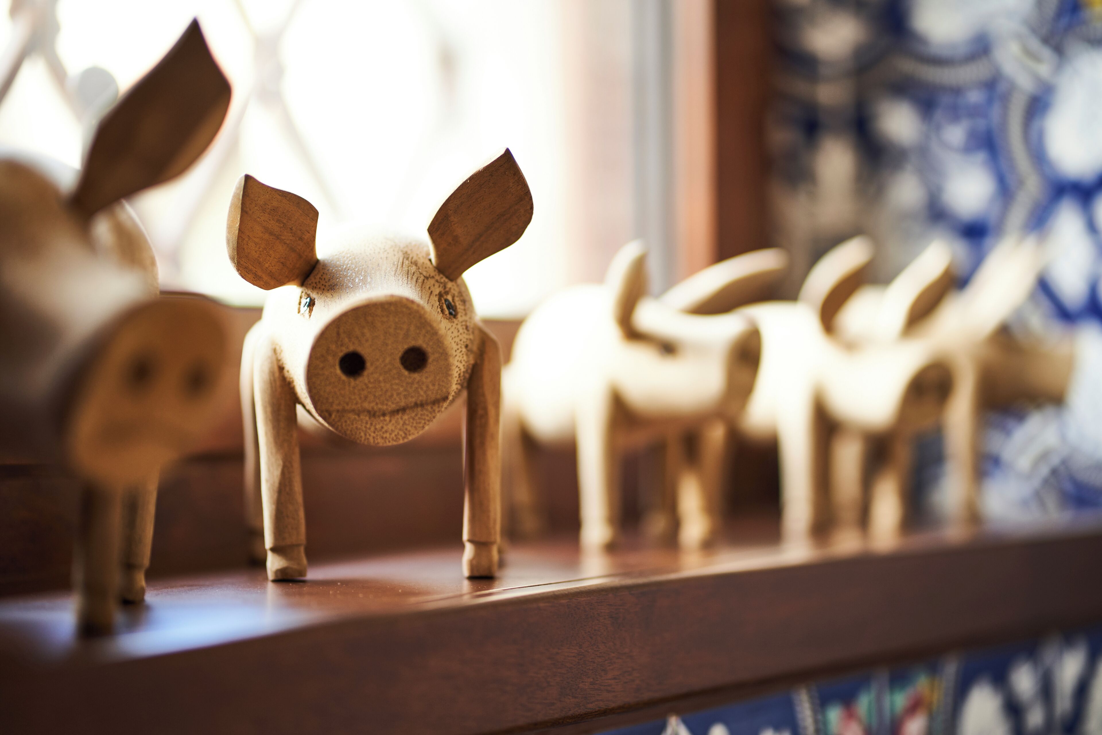 Figuras de animales de madera sobre una estantería.