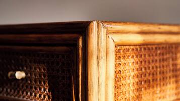 A close-up of a wooden chair with a woven backrest and a metal frame.
